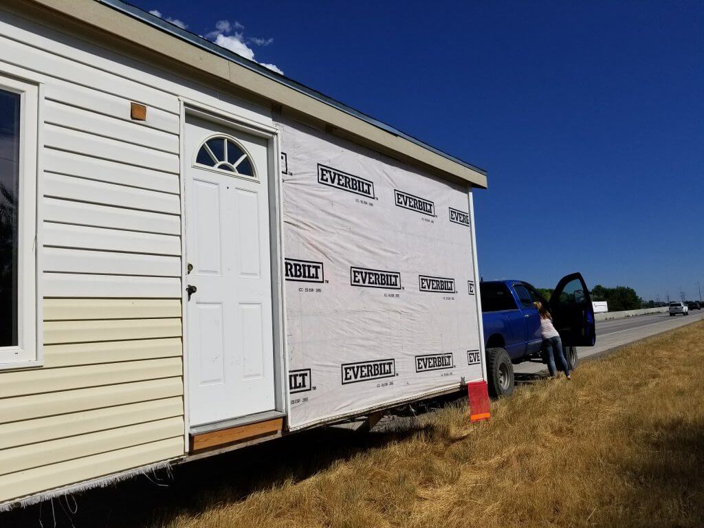 Picture showing the siding from the passenger side of the tiny house missing; additional siding from the front was also missing (not pictured).